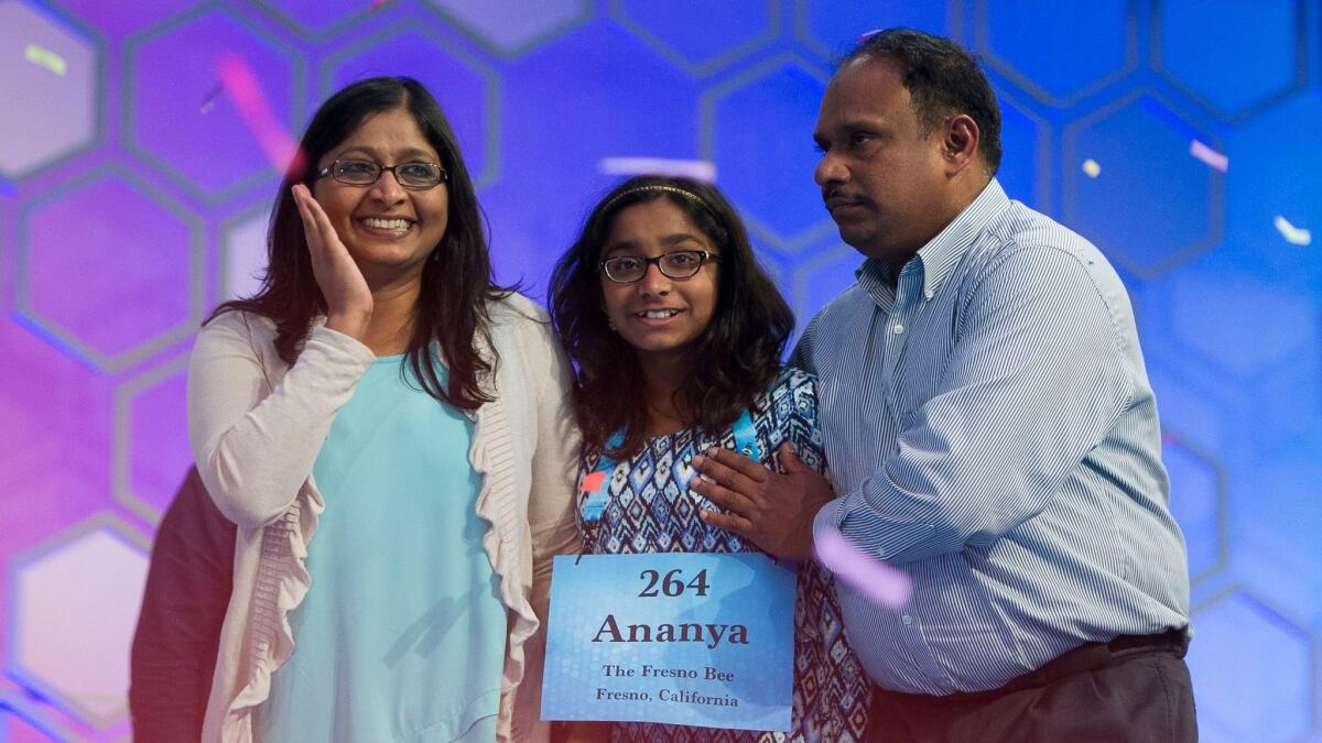 Ananya Vinay, 12, of Fresno celebrates onstage with her parents, Anu Pama Poliyedathpp, left, and Vinay Sreekumar.