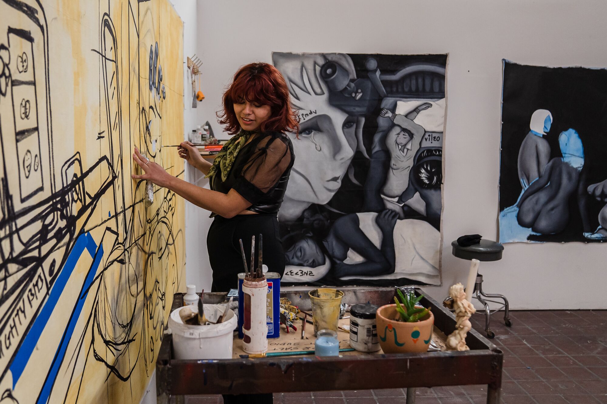 La artista y música Vanessa Rishel pinta en un lienzo en la pared de Bread & Salt.