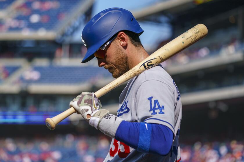 Los Angeles Dodgers' Cody Bellinger looks down while holding a bat on his shoulder