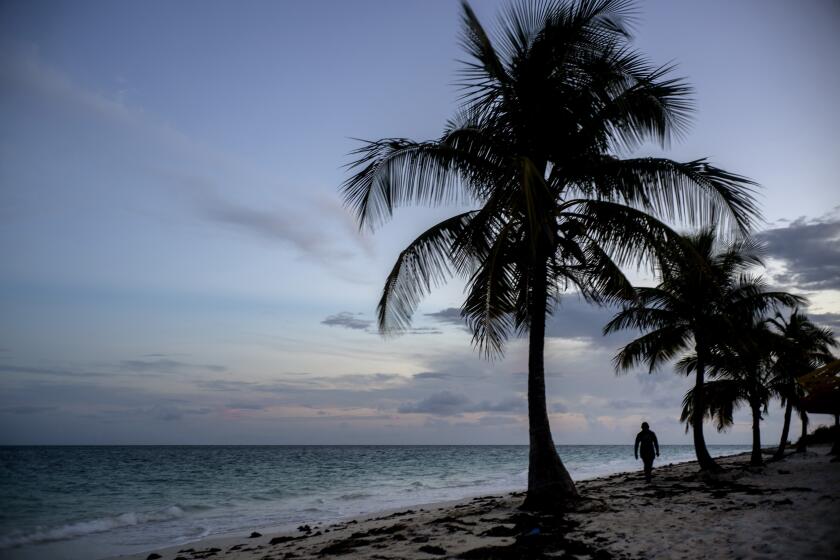 A woman walks along a beach before the arrival of Hurricane Dorian in Freeport, Grand Bahama, Bahamas, Saturday Aug. 31, 2019. Hurricane Dorian is closing in on the northern Bahamas, threatening to batter the normally idyllic islands with fierce winds, pounding waves and torrential rain. (AP Photo/Ramon Espinosa)