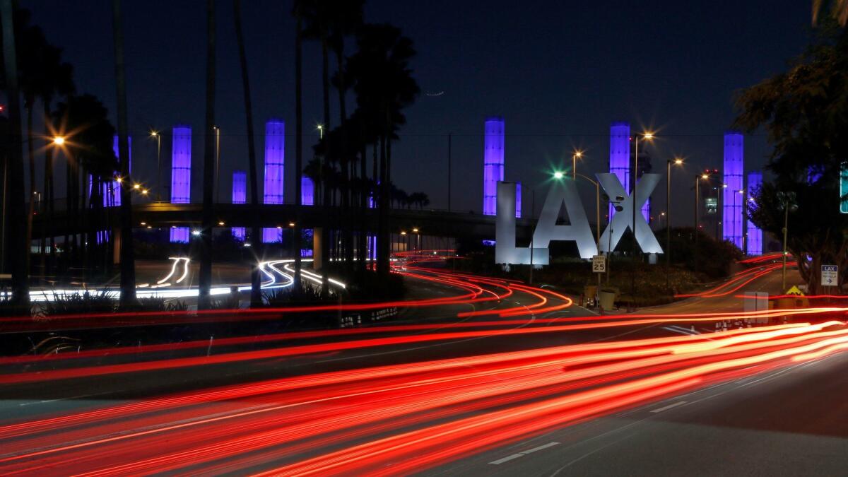 Pylons light up at the Century Boulevard entrance to Los Angeles International Airport. Travelers gave airports higher satisfaction ratings in 2016 despite bigger crowds, according to a new survey.