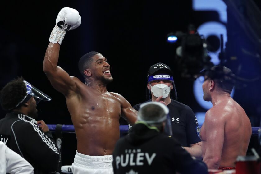 Anthony Joshua, left, celebrates after beating Kubrat Pulev in their heavyweight title fight in London on Dec. 12, 2020.
