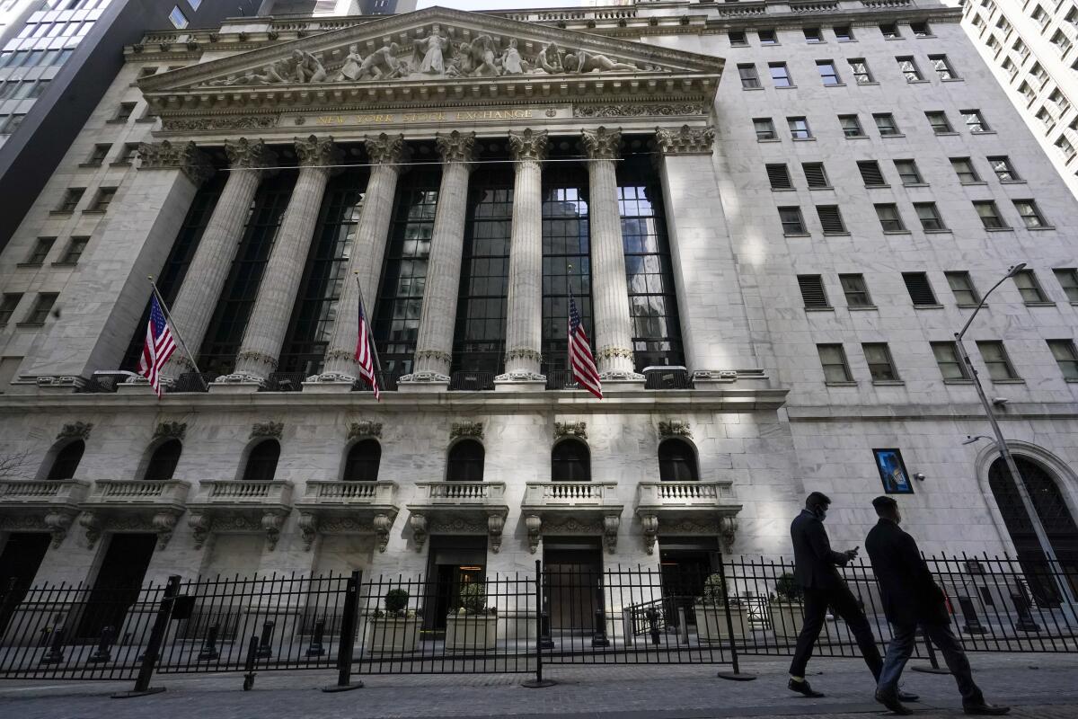 Pedestrians walk past the New York Stock Exchange.