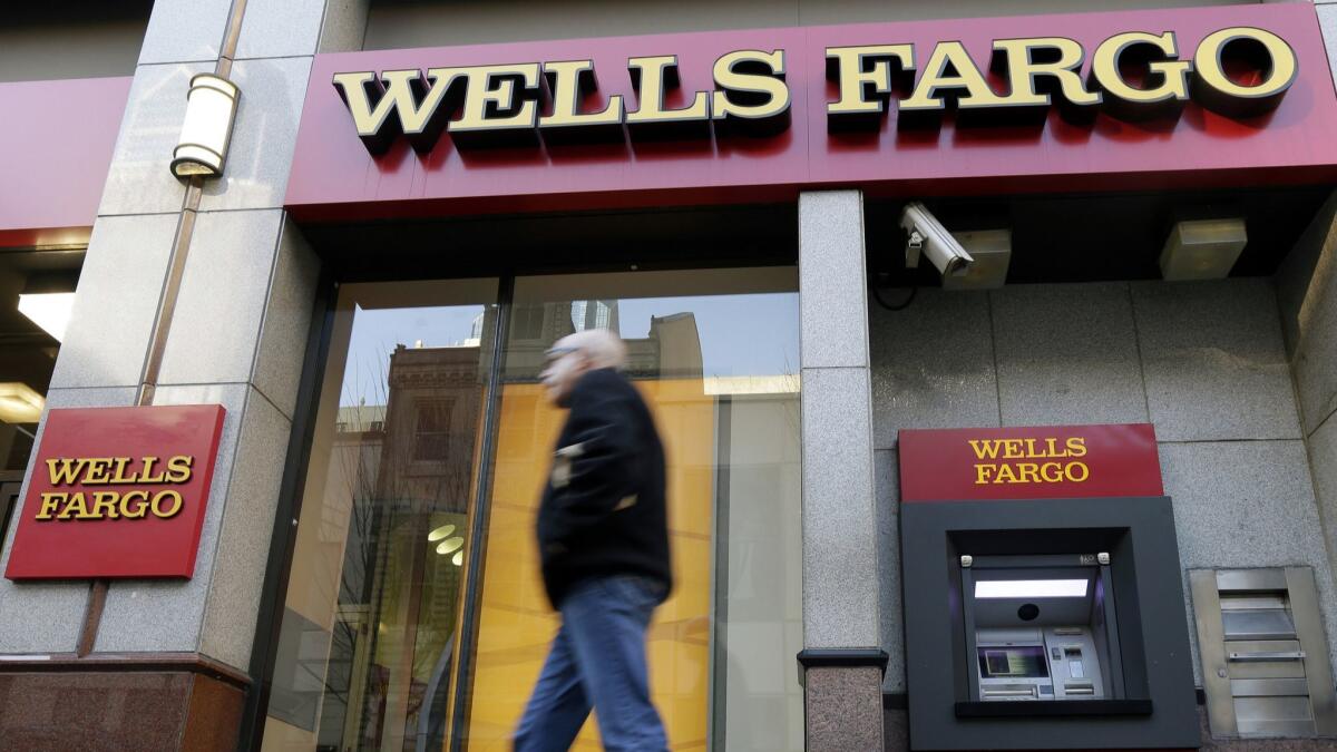 A man walks past a Wells Fargo bank branch.