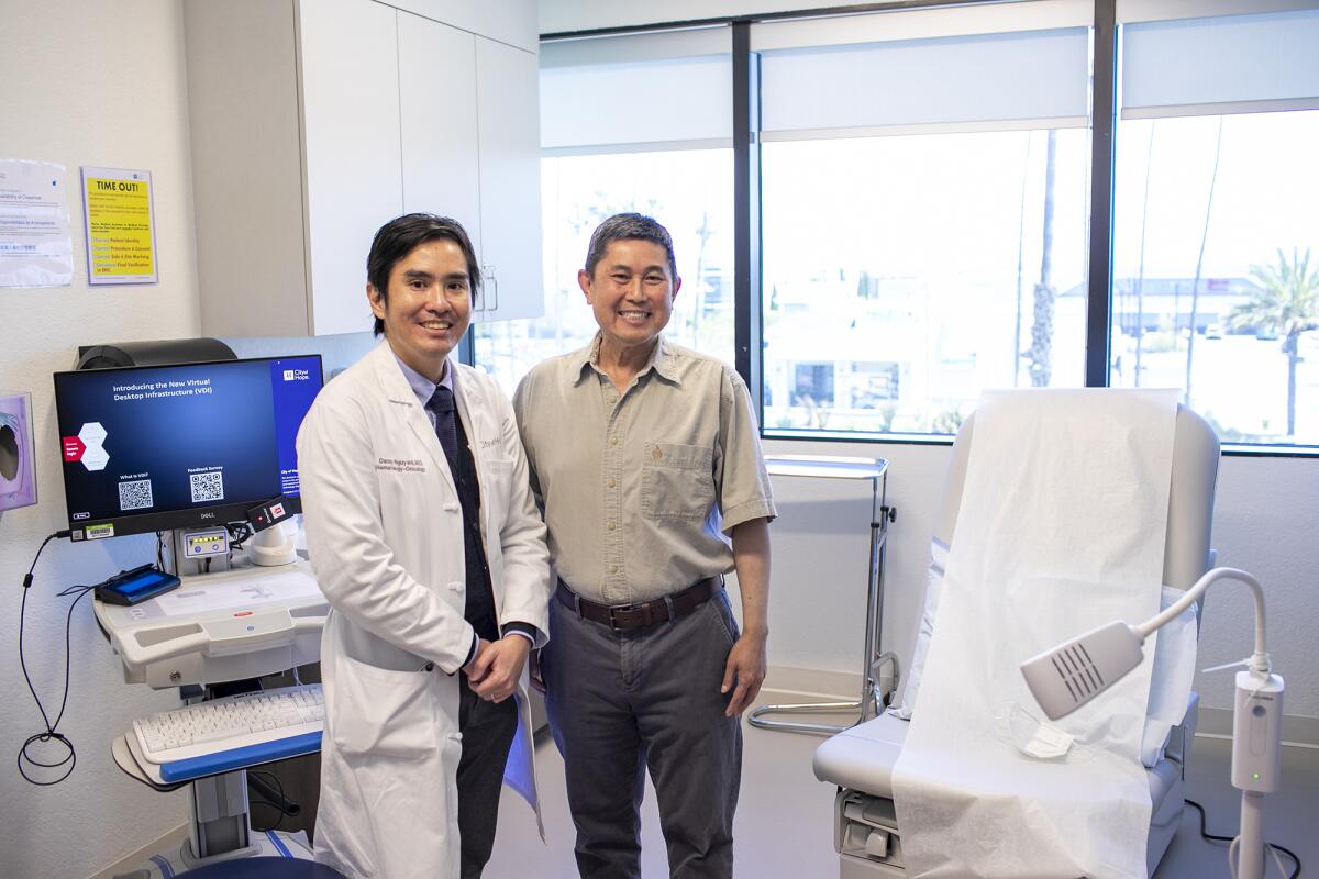 Dr. Danny Nguyen with John Ryan, a 59-year-old Vietnamese American, on May 3 in Huntington Beach.