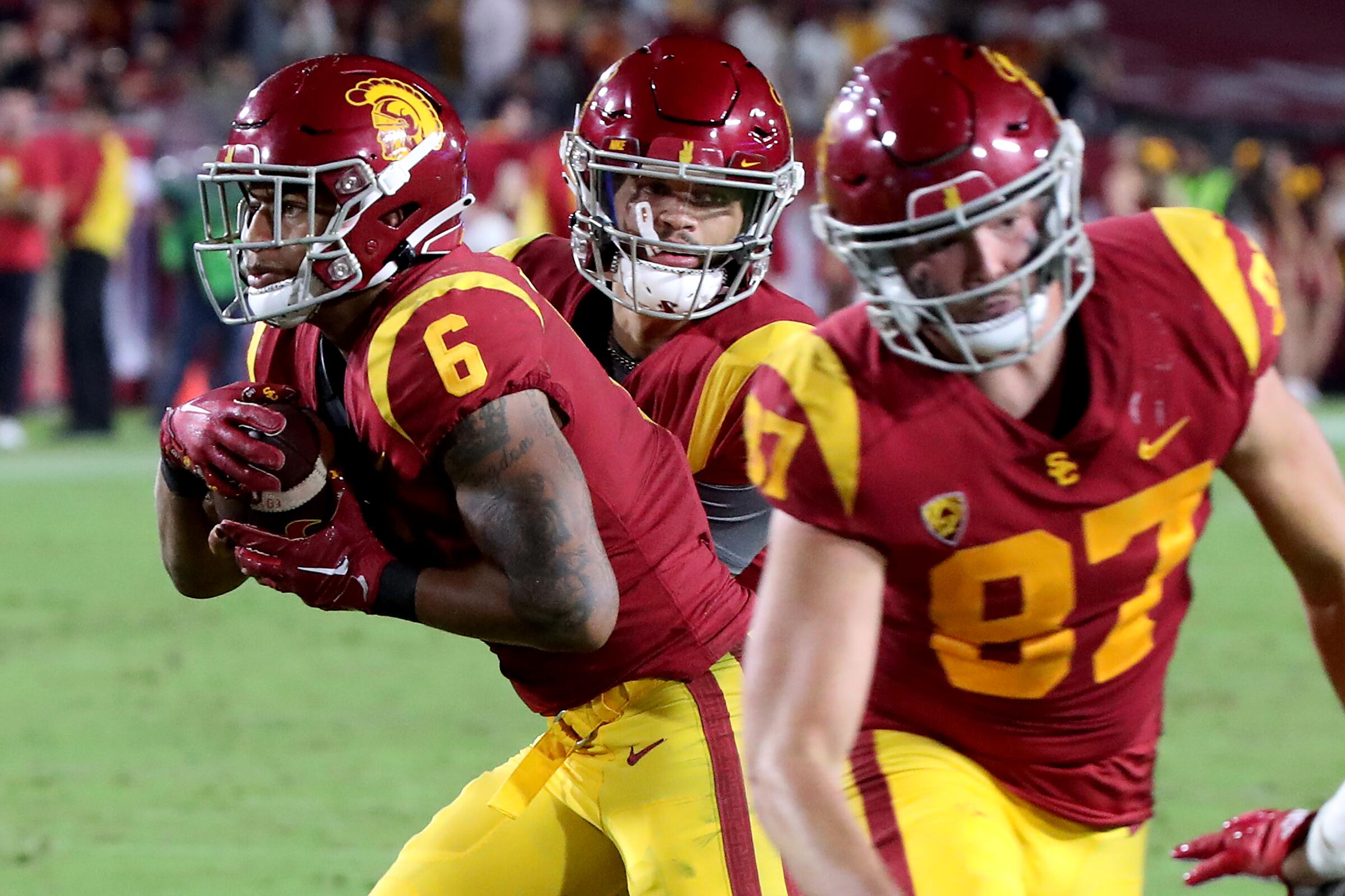 USC quarterback Caleb Williams, center, hands off to running back Austin Jones, left, during a win over Fresno State.