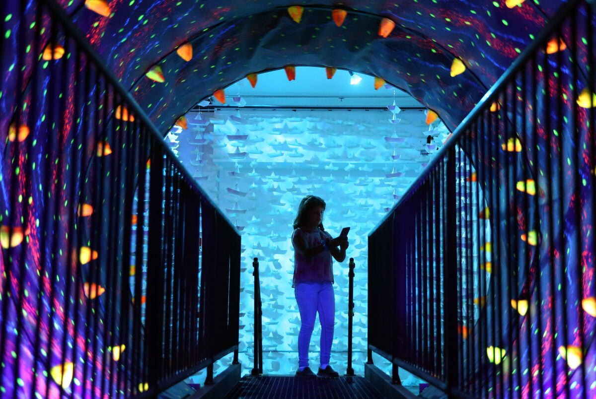 Bettina Diaz, 10, takes a picture inside a tunnel at the "I Like Scary Movies" art exhibit downtown.
