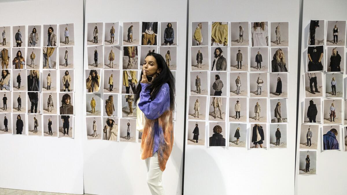 Buyer Sara Merabet from RSVP Gallery in front of campaign photos from Fear of Gold. Models for the campaign include Jared Leto and Maggie Maurer.