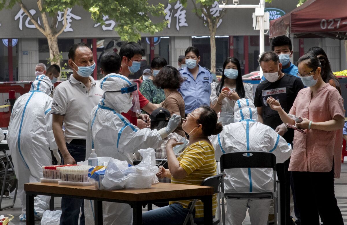 People line up for coronavirus testing in Wuhan, China, where the city government has required that all residents be tested after new cases were reported.