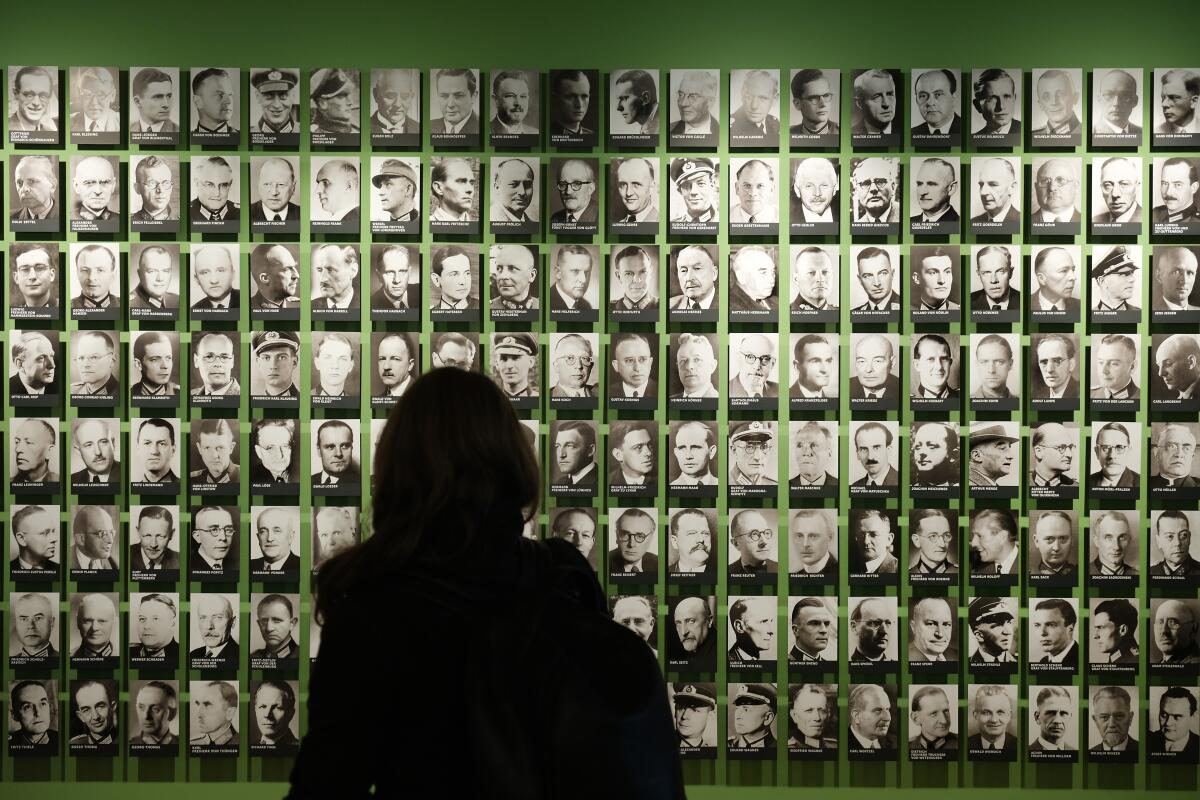 A visitor looks at portraits of members of the World War II German resistance July 8 at the German Resistance Memorial Center in Berlin. Claus von Stauffenberg is visible at bottom right,