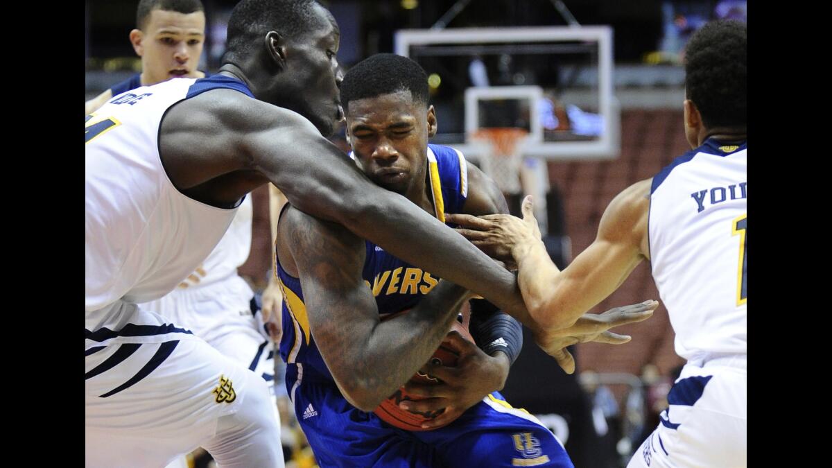 UC Riverside guard Jaylen Bland is fouled by UC Irvine center Mamadou Ndiaye, left, as he tries to drive past Ndiaye and teammate Alex Young.