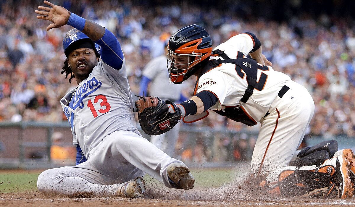 Dodgers shortstop Hanley Ramirez (13) beats the tag of Giants catcher Buster Posey to score in a game earlier this season. The two middle-of-the-order hitters could plays vital roles in a division race that heats up this weekend.