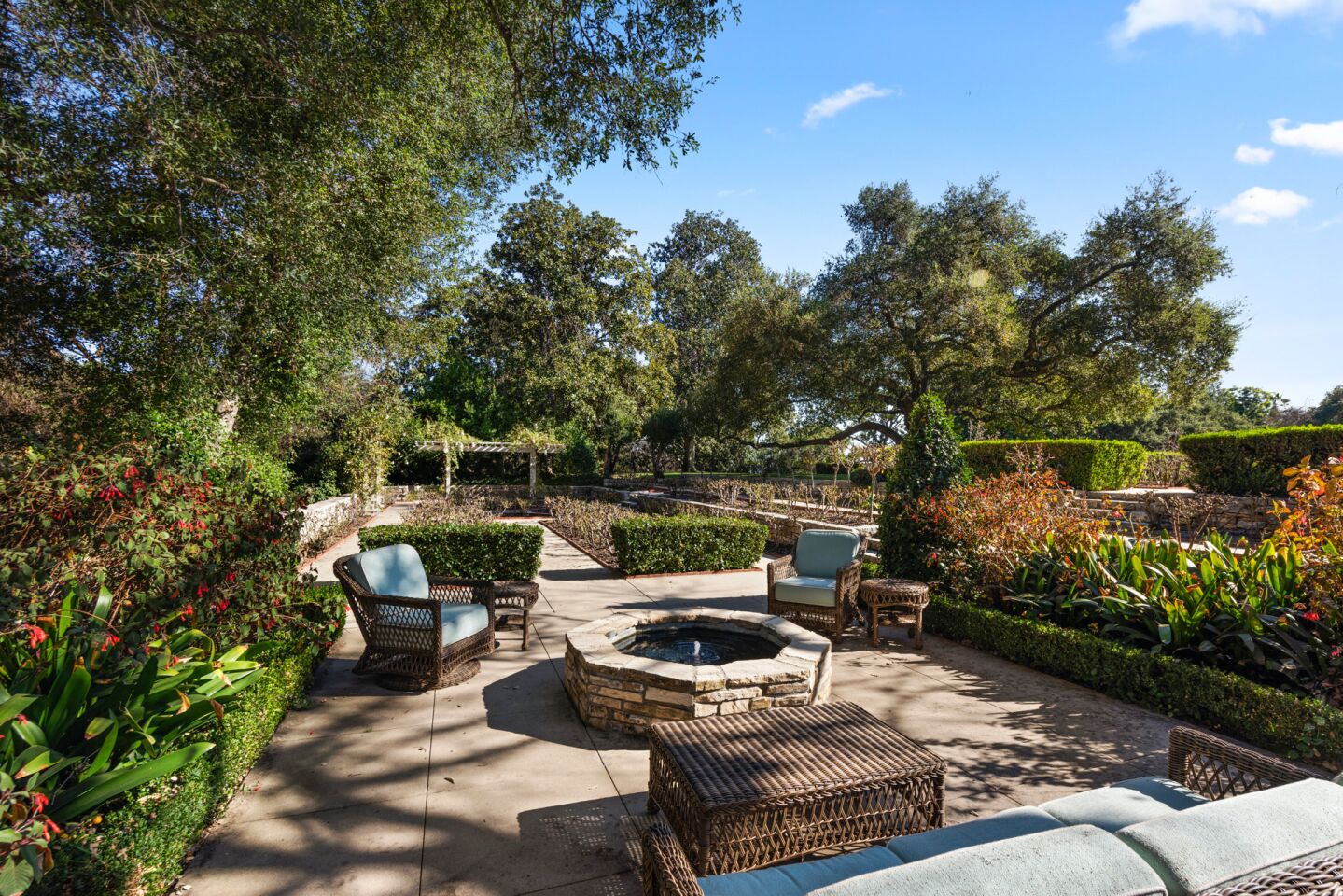 The fire pit outdoors surrounded by chairs and trees