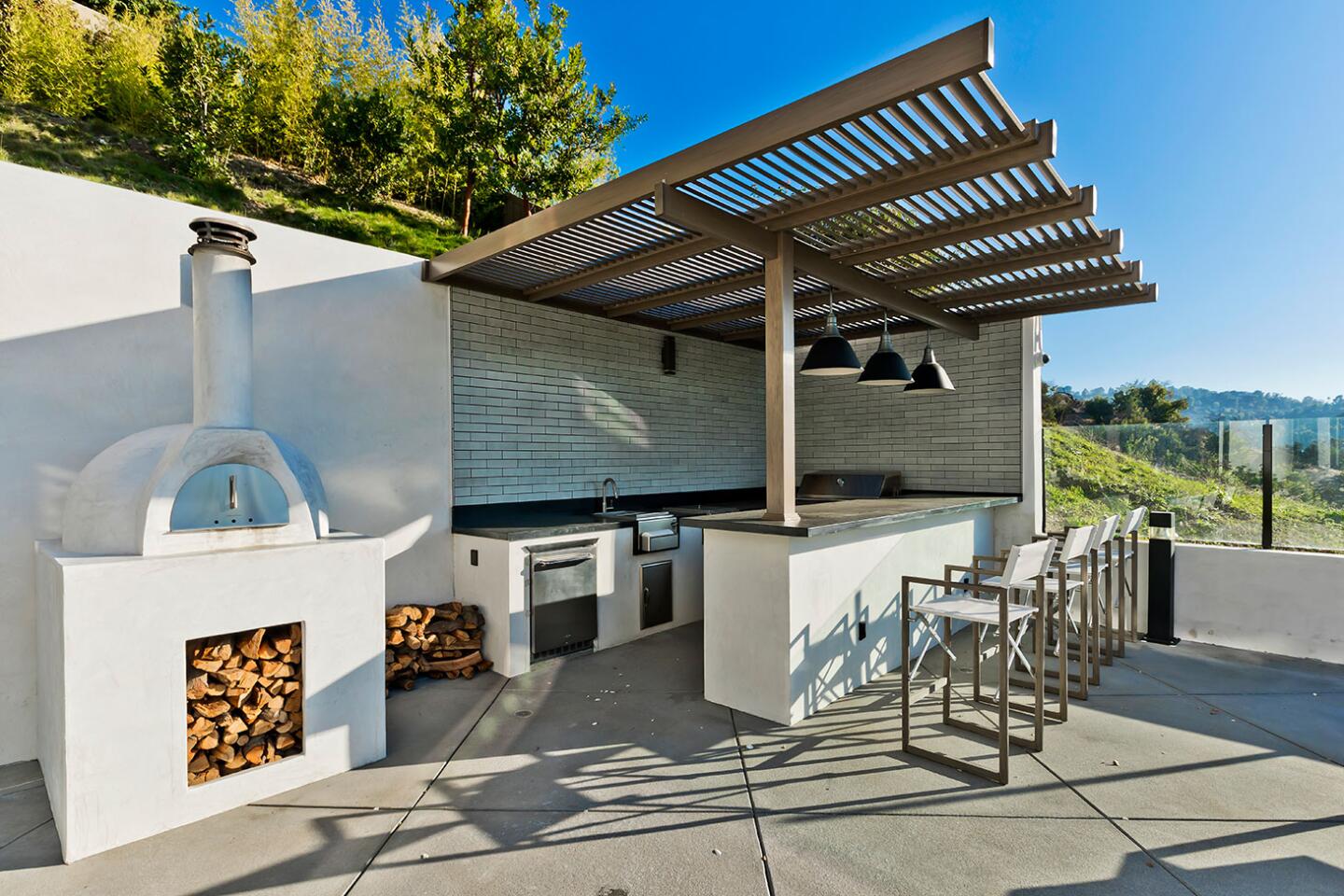 The outdoor kitchen has a pizza oven.