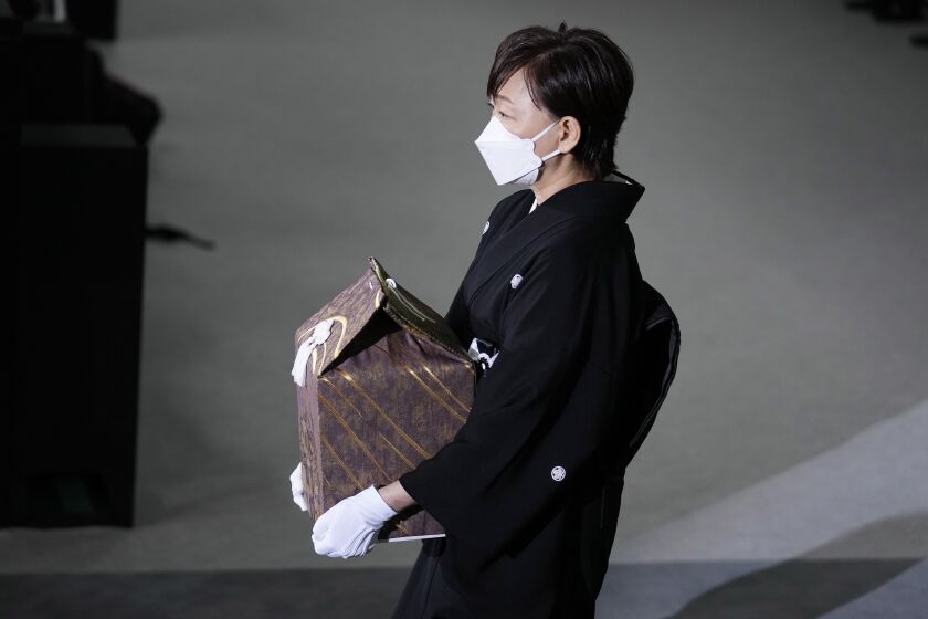 Akie Abe, wife of former Prime Minister Shinzo Abe, carries a cinerary urn containing his ashes at his state funeral, Tuesday, Sept. 27, 2022, in Tokyo. Abe was assassinated in July. (Franck Robichon/Pool photo via AP)