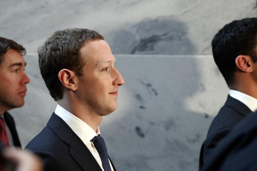 Facebook cofounder Mark Zuckerberg smiles while shown in profile.
