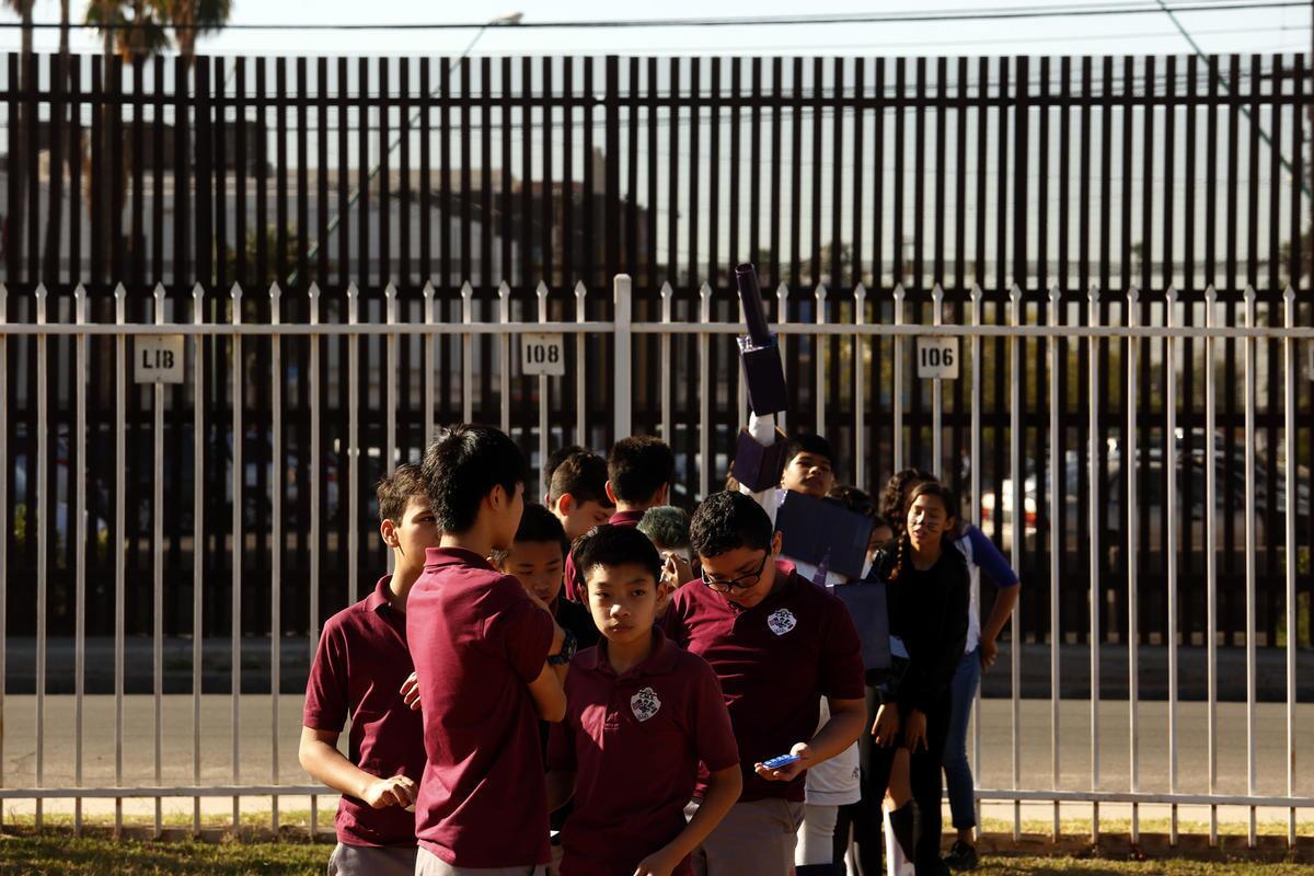 Estudiantes de Calexico Mission School junto a la valla de la escuela, enmarcada por la cerca fronteriza, durante un simulacro de incendio realizado en Caléxico, California (Genaro Molina / Los Angeles Times).