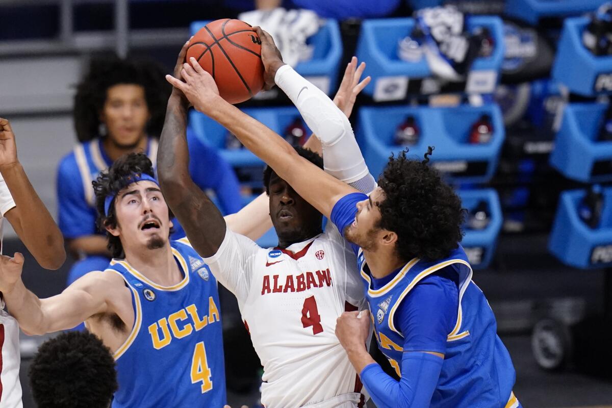 Alabama forward Juwan Gary protects the ball from UCLA guard Johnny Juzang and Jaime Jaquez Jr. 