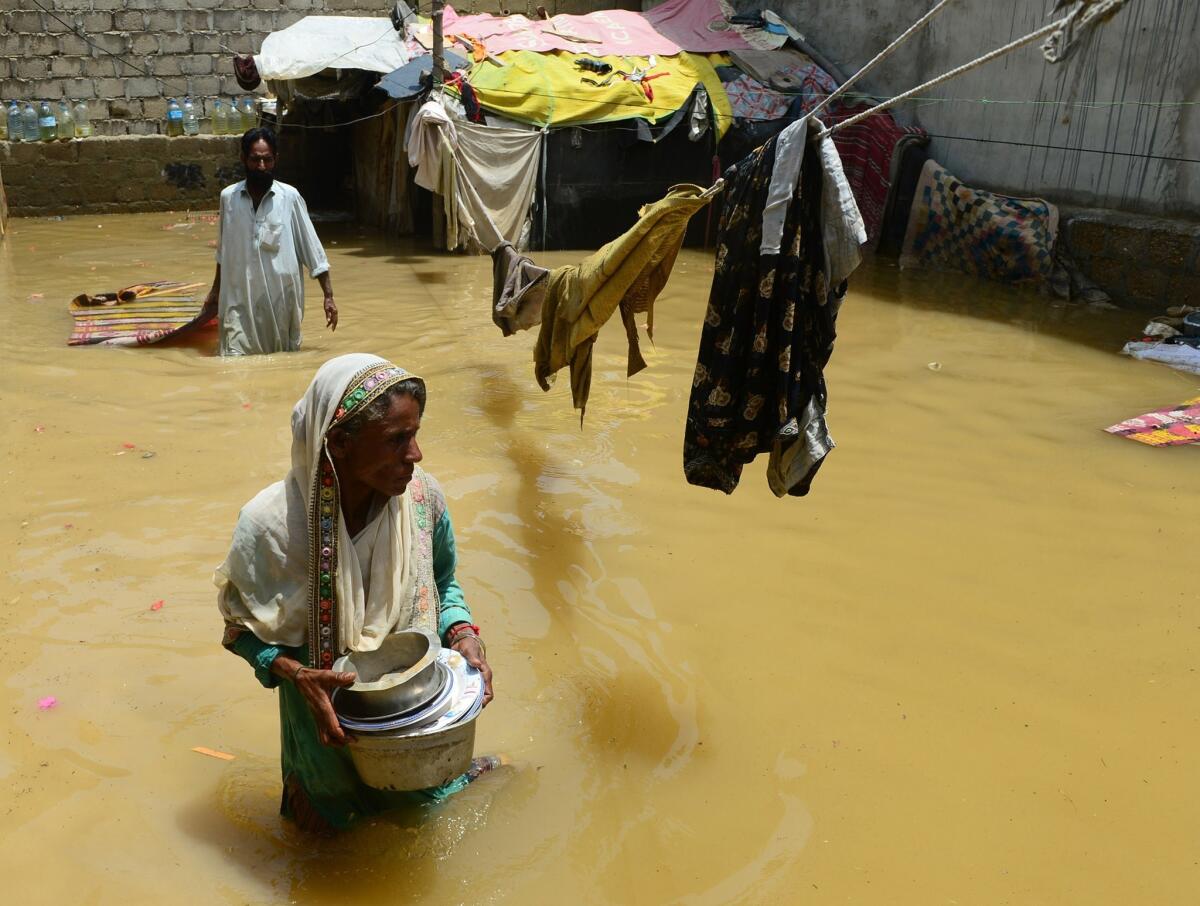 A woman walks through floodwaters after heavy monsoon rain in Karachi, Pakistan.