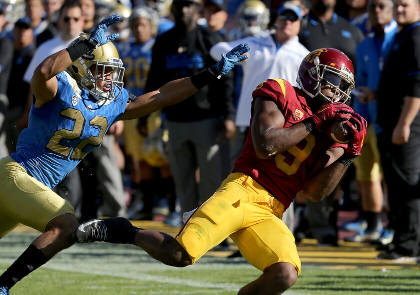 USC wide receiver Juju Smith-Schuster makes a catch in front of UCLA defensive back Nate Meadors on Nov. 28.