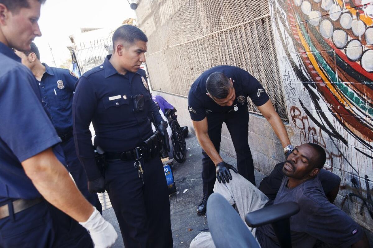 Fire Department personnel provide assistance to a man believed to be feeling the effects of a synthetic cannabinoid called spice on Monday, Aug. 22, 2016, in downtown's Skid Row
