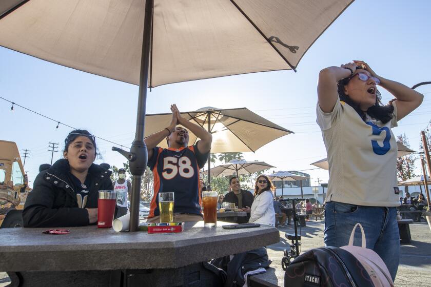Inglewood, CA - January 30: Rams fans from right, Marilyn Monterrojas, Jesus Cisneros and Jocelyn Monerrojas react as Rams turn over the ball in the engine on an interception in the first quarter while watching the game at Three Weavers Brewing Sunday, Jan. 30, 2022 in Inglewood, CA. (Brian van der Brug / Los Angeles Times)