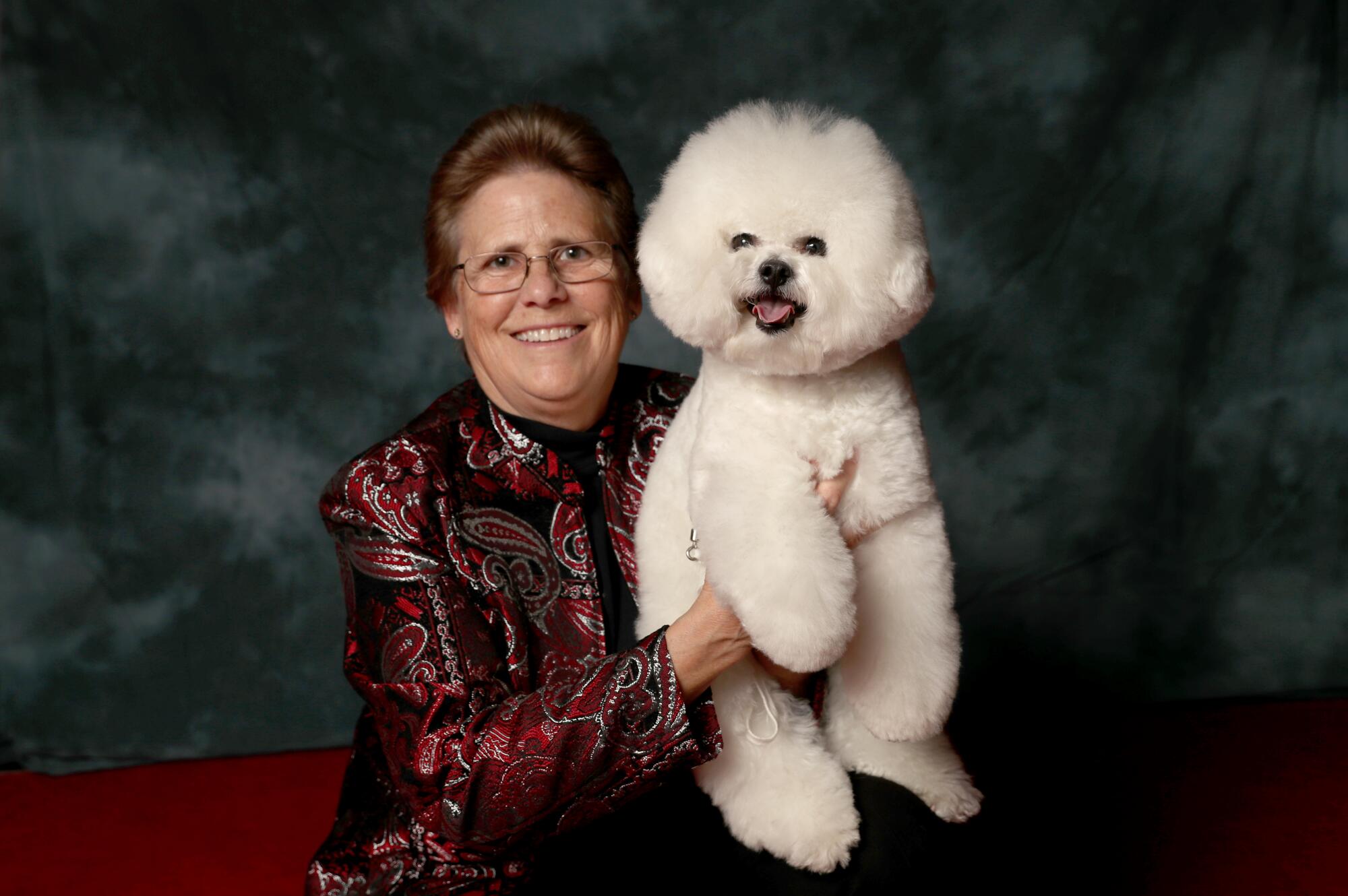 Debbie Gibb, 63, of San Diego, poses with Jack, a bichon frise, at the Kennel Club of Beverly Hills Dog Show