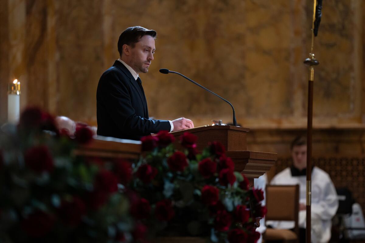 Kieran Culkin's character Roman Roy stands at a church lectern in an episode of "Succession."