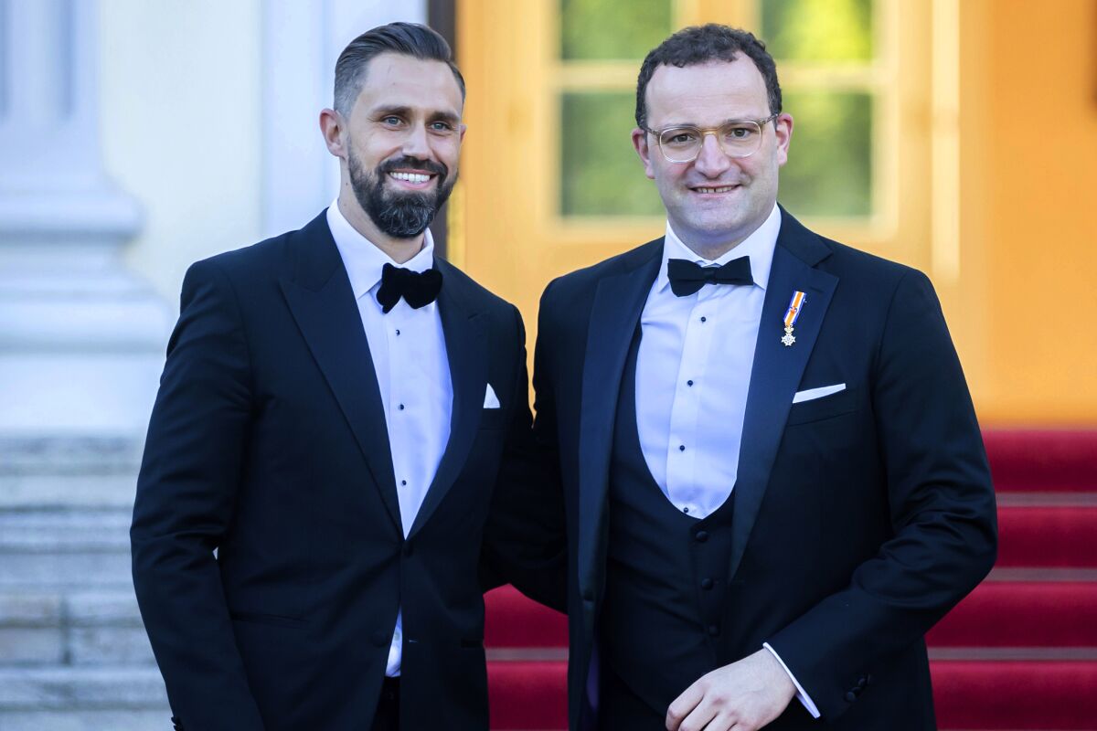 FILE-In this July 5, 2021 taken photo shows German Health Minister Jens Spahn, right, and his husband Daniel Funke, left, arriving at Bellevue presidential palace to attend a State banquet hosted by the Federal President and his wife in Berlin. Germany's health minister, who has been an ever-present appearance in the country's media and public since the outbreak of the coronavirus pandemic, has criticized the Catholic Church for its refusal to bless same-sex couples. (AP Photo/Christoph Soeder)