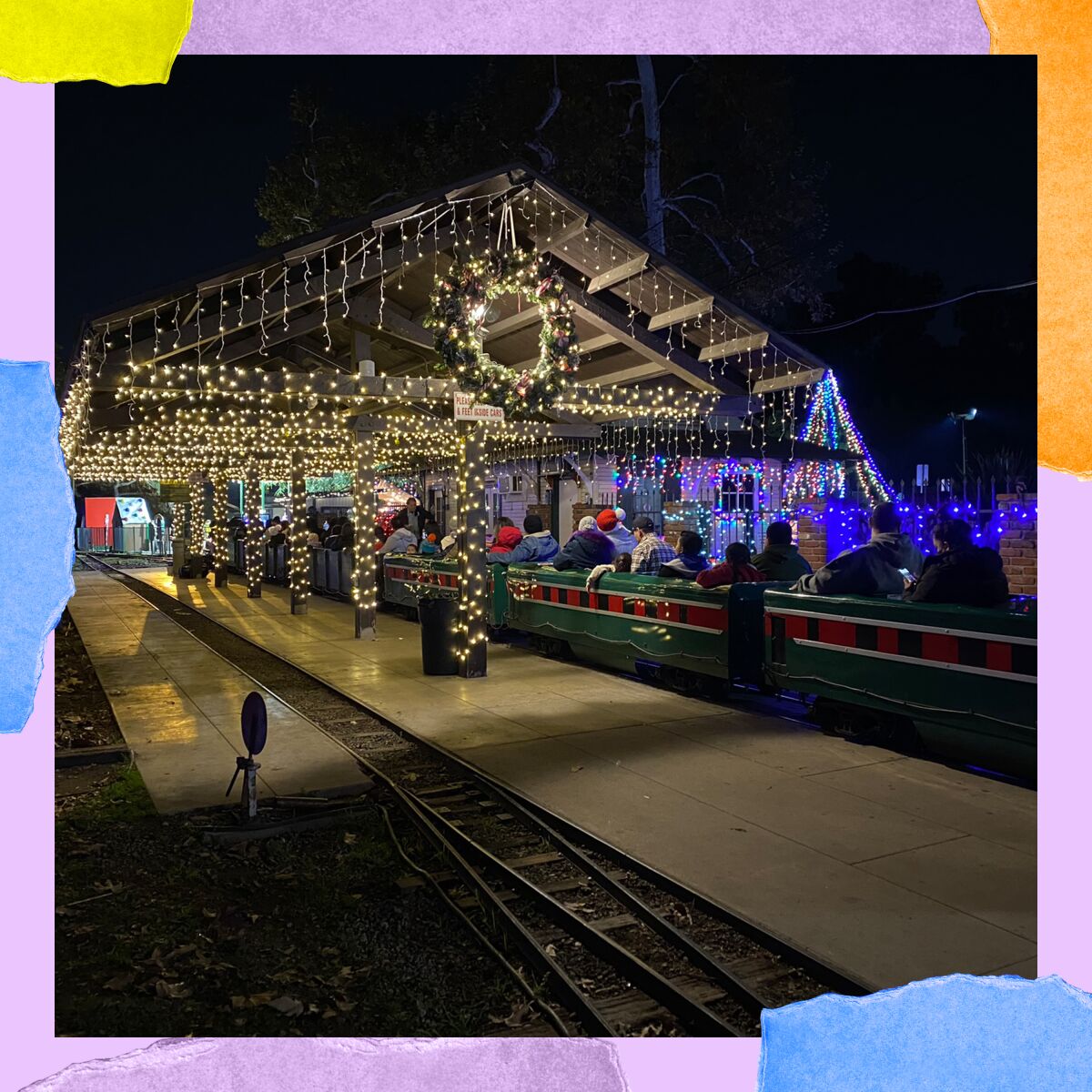 An outdoor train depot covered with Christmas lights.