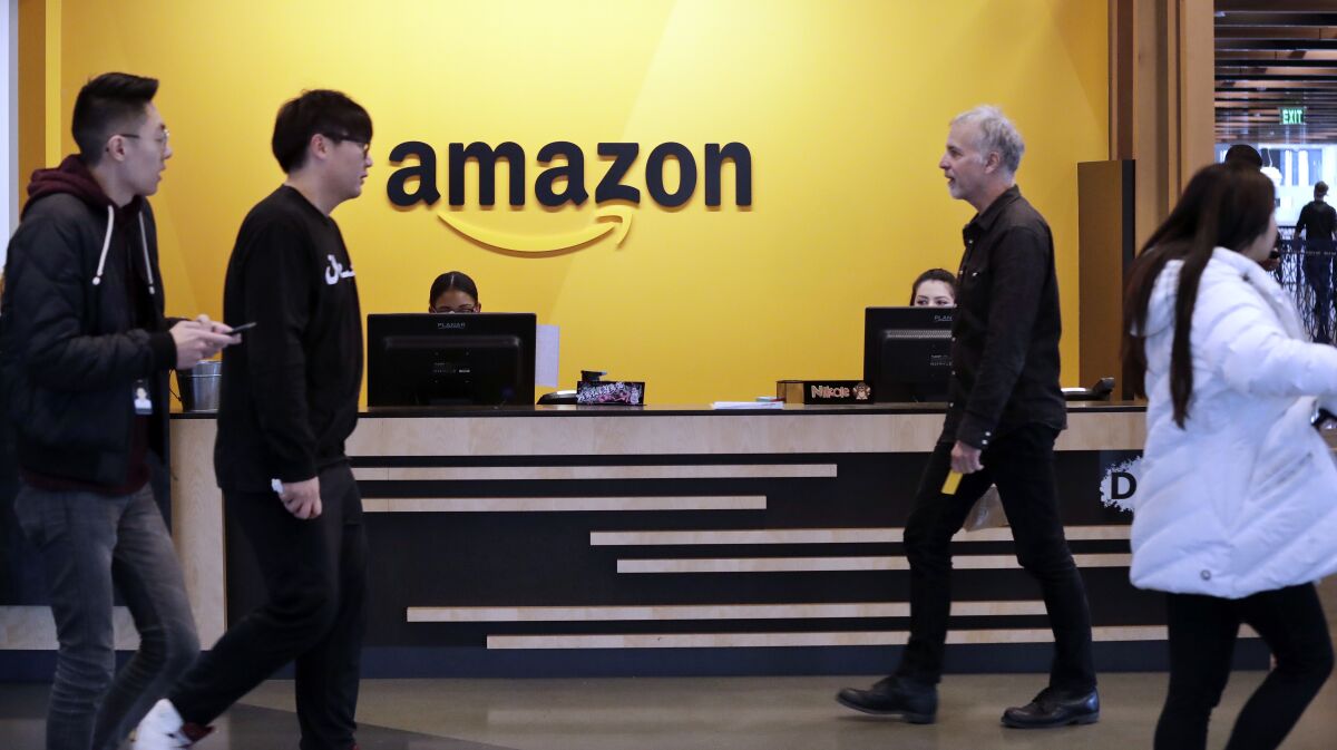 Employees walk through a lobby at Amazon's headquarters in Seattle.