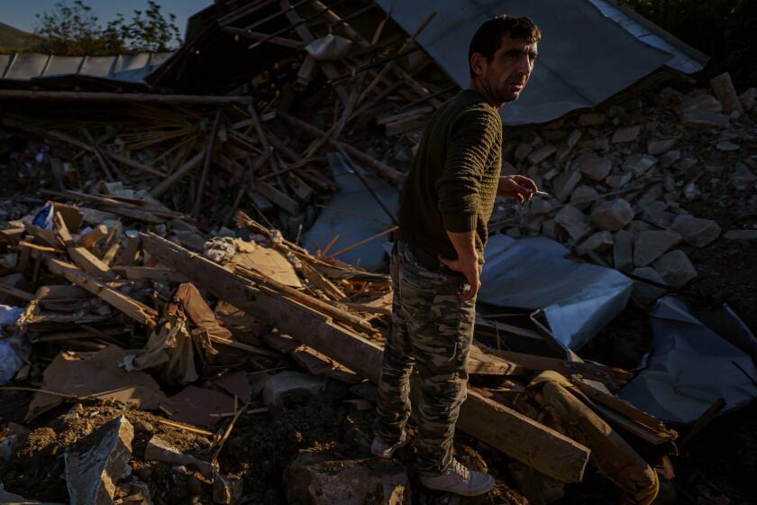 A man looks over a wreckage of a home destroyed by a military strike in Martuni, Nagorno-Karabakh.