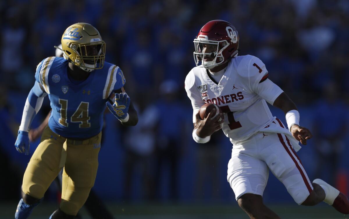 UCLA linebacker Krys Barnes (14) pursues Oklahoma quarterback Jalen Hurts during a game at the Rose Bowl on Sept. 14.