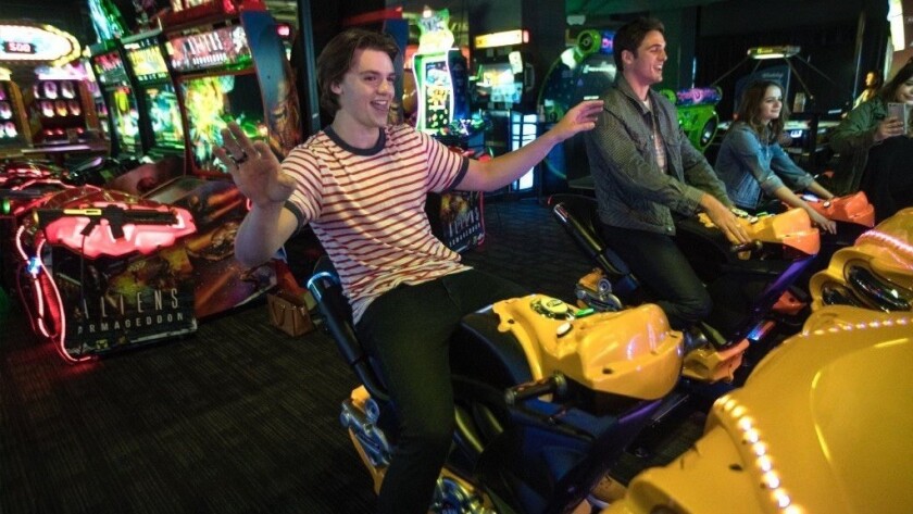 The stars of the Netflix movie "The Kissing Booth," (left to right) Joel Courtney, Jacob Elordi and Joey King, try out a motorcycle racing game at Dave & Busters.