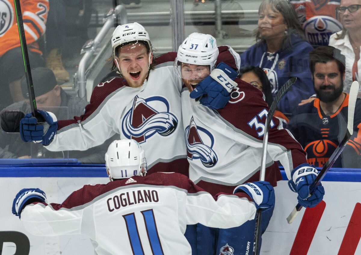 Colorado Avalanche's Bowen Byram (4), J.T. Compher (37) and Andrew Cogliano (11) celebrate a goal against the Edmonton Oilers during the third period of Game 3 of the NHL hockey Stanley Cup playoffs Western Conference finals, Saturday, June 4, 2022, in Edmonton, Alberta. (Amber Bracken/The Canadian Press via AP)