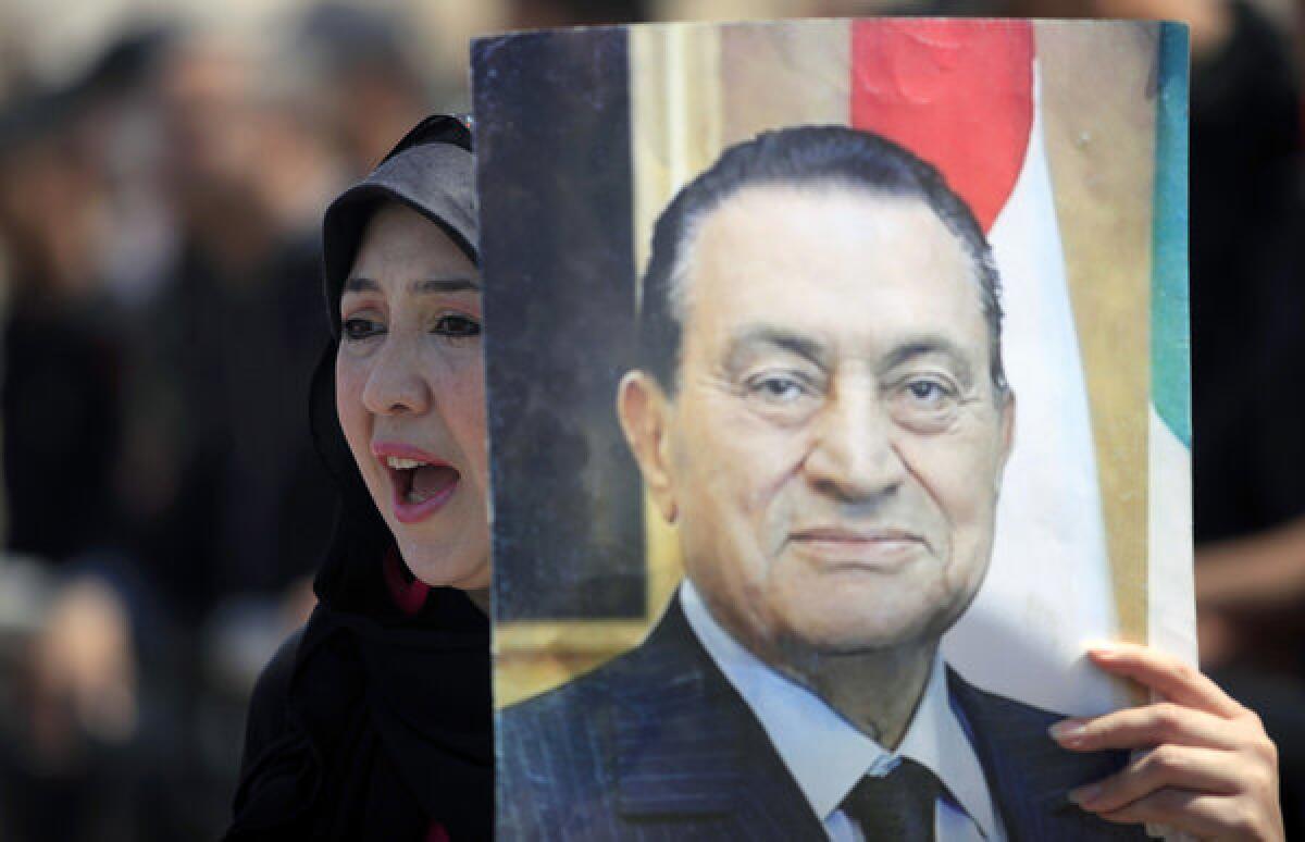 A supporter of Egypt's ousted president, Hosni Mubarak, takes part in a rally outside a courtroom in Cairo.