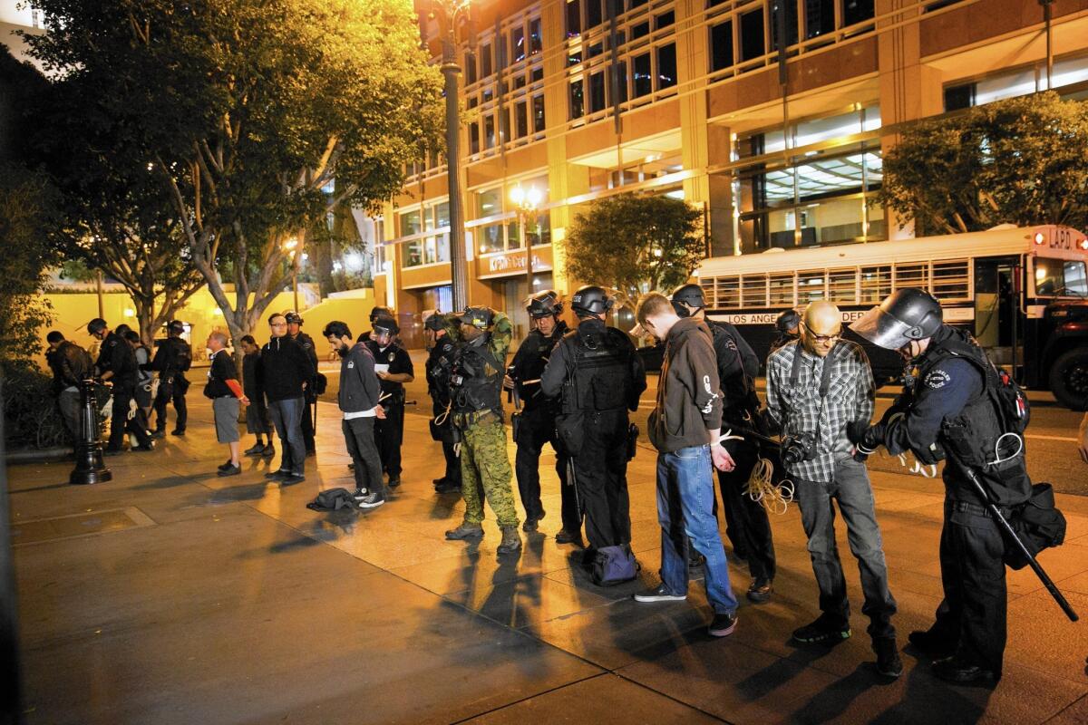 LAPD officers search protesters arrested in downtown Los Angeles on the third day of demonstrations over the failure to charge the Ferguson, Mo., police officer who shot Michael Brown to death.