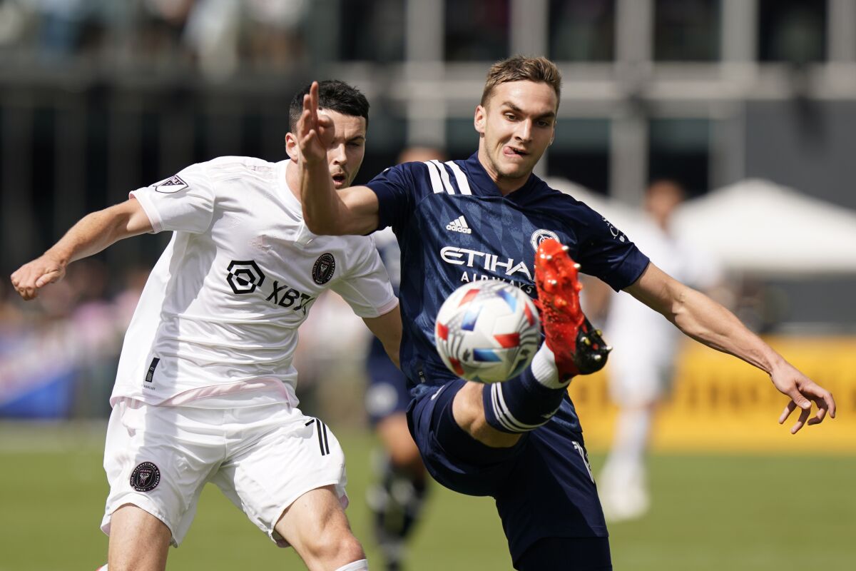 New York City FC midfielder James Sands, right, kicks the ball to a teammate as he is pursued by Inter Miami midfielder Lewis Morgan, Saturday, Oct. 30, 2021, during the first half of an MLS soccer match in Fort Lauderdale, Fla. (AP Photo/Wilfredo Lee)