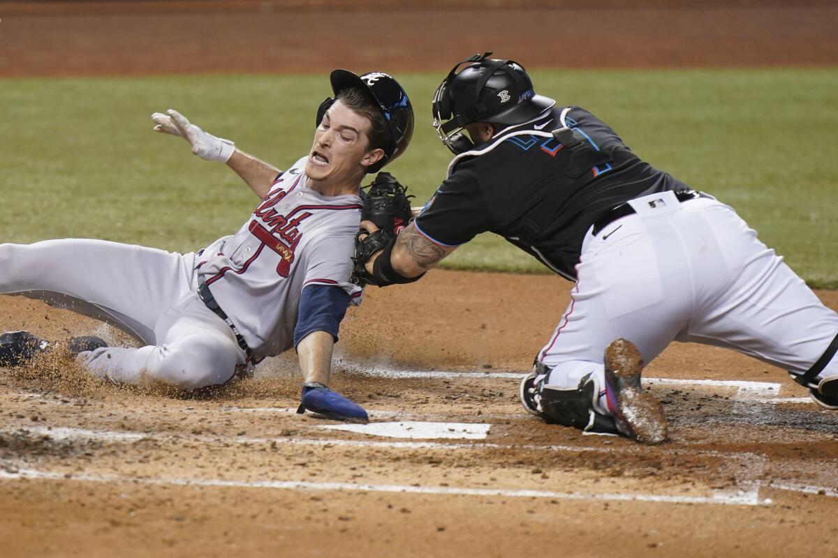 Miami Marlins catcher Sandy Leon (7) tags out Atlanta Braves' Max Fried at home during the third inning of a baseball game, Saturday, June 12, 2021, in Miami. (AP Photo/Wilfredo Lee)