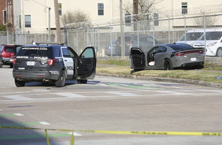 Authorities investigate the scene of a shooting Thursday, Jan. 27, 2022, in Houston. Authorities say a police chase in Houston ended with a shootout that wounded three officers. The incident happened about 2:40 p.m. Thursday when a car that police were pursuing crashed at an intersection just off Interstate 69 on the southeastern edge of downtown Houston. ( Jon Shapley/Houston Chronicle via AP)