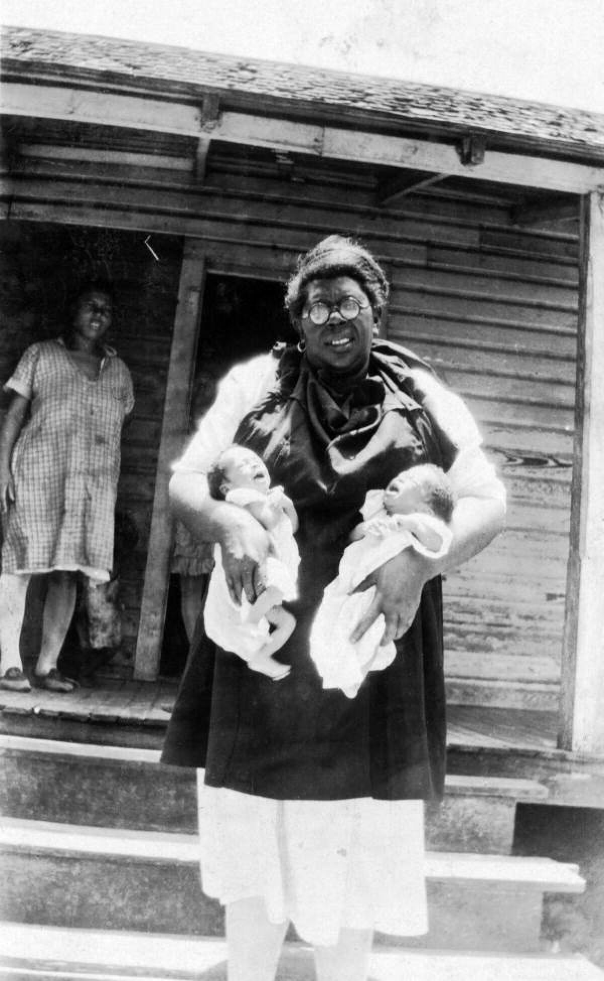 A Florida midwife holds twins in this undated photo.