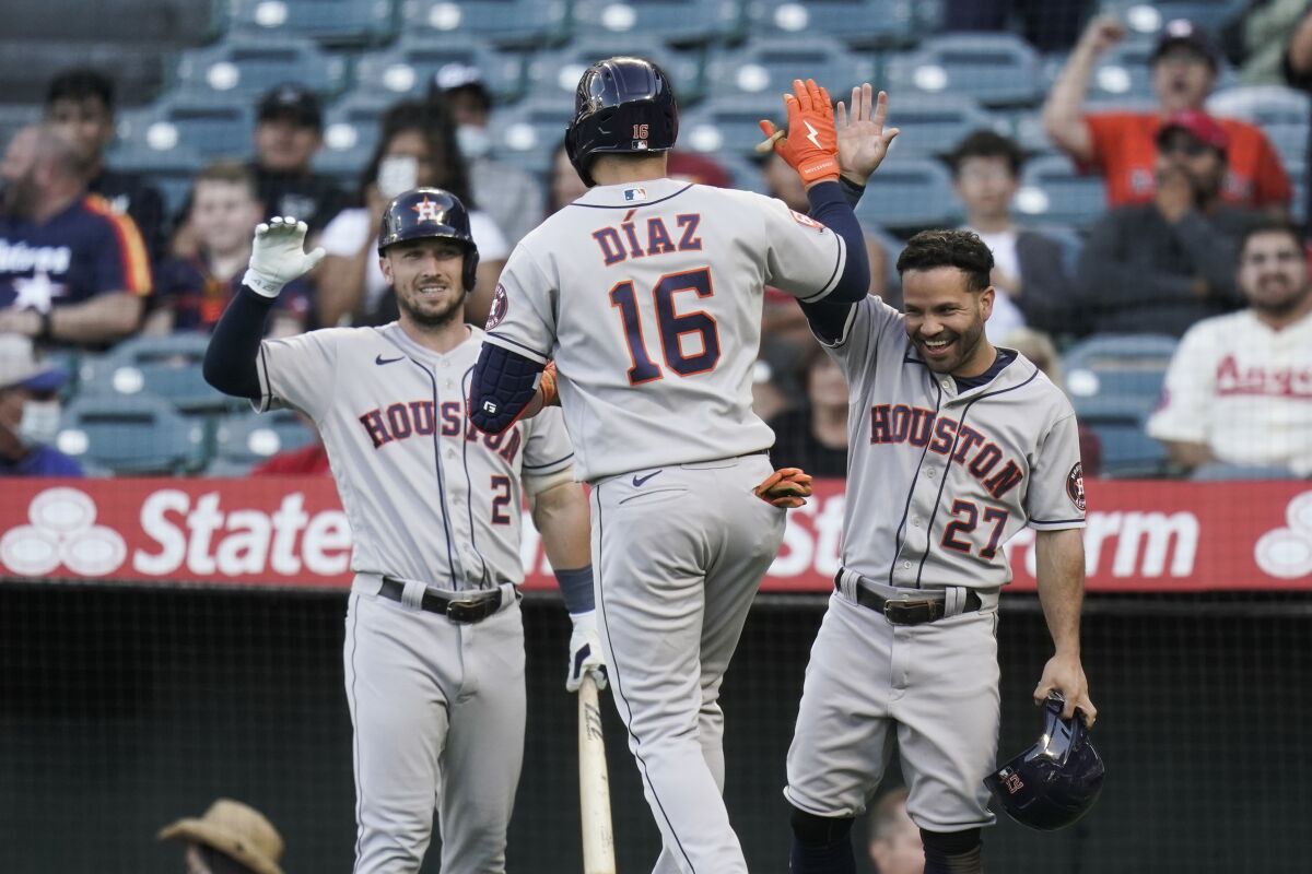 Houston Astros' Aledmys Diaz (16) celebrates his two-run home run with Jose Altuve (27) and Alex Bregman (2) during the first inning of a baseball game against the Los Angeles Angels Tuesday, July 12, 2022, in Anaheim, Calif. (AP Photo/Jae C. Hong)