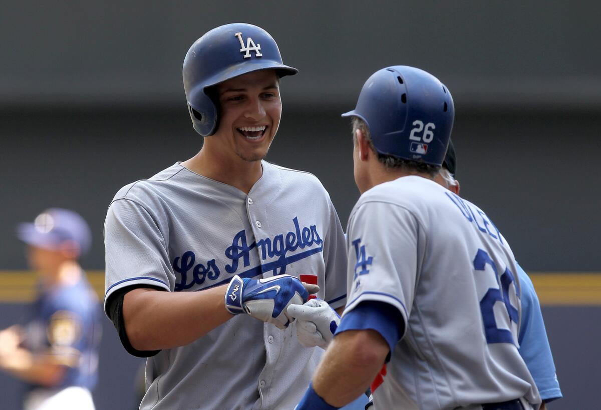 Dodgers shortstop Corey Seager (5) is congratulated by Chase Utley after hitting a home run against the Milwaukee Brewers on June 30.