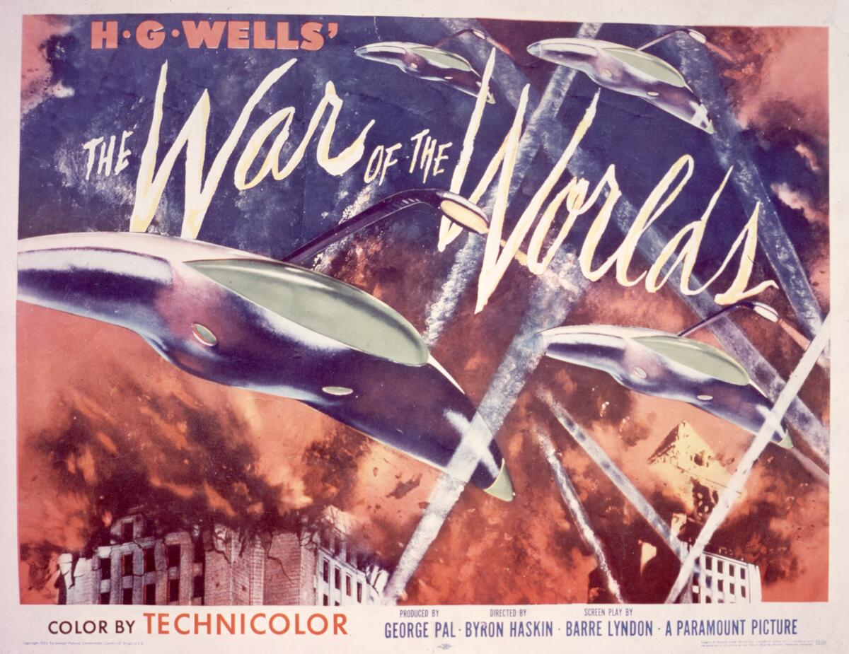 A movie poster for H.G. Wells' 'The War Of The Worlds'  shows flying saucers and smoke and fire over buildings