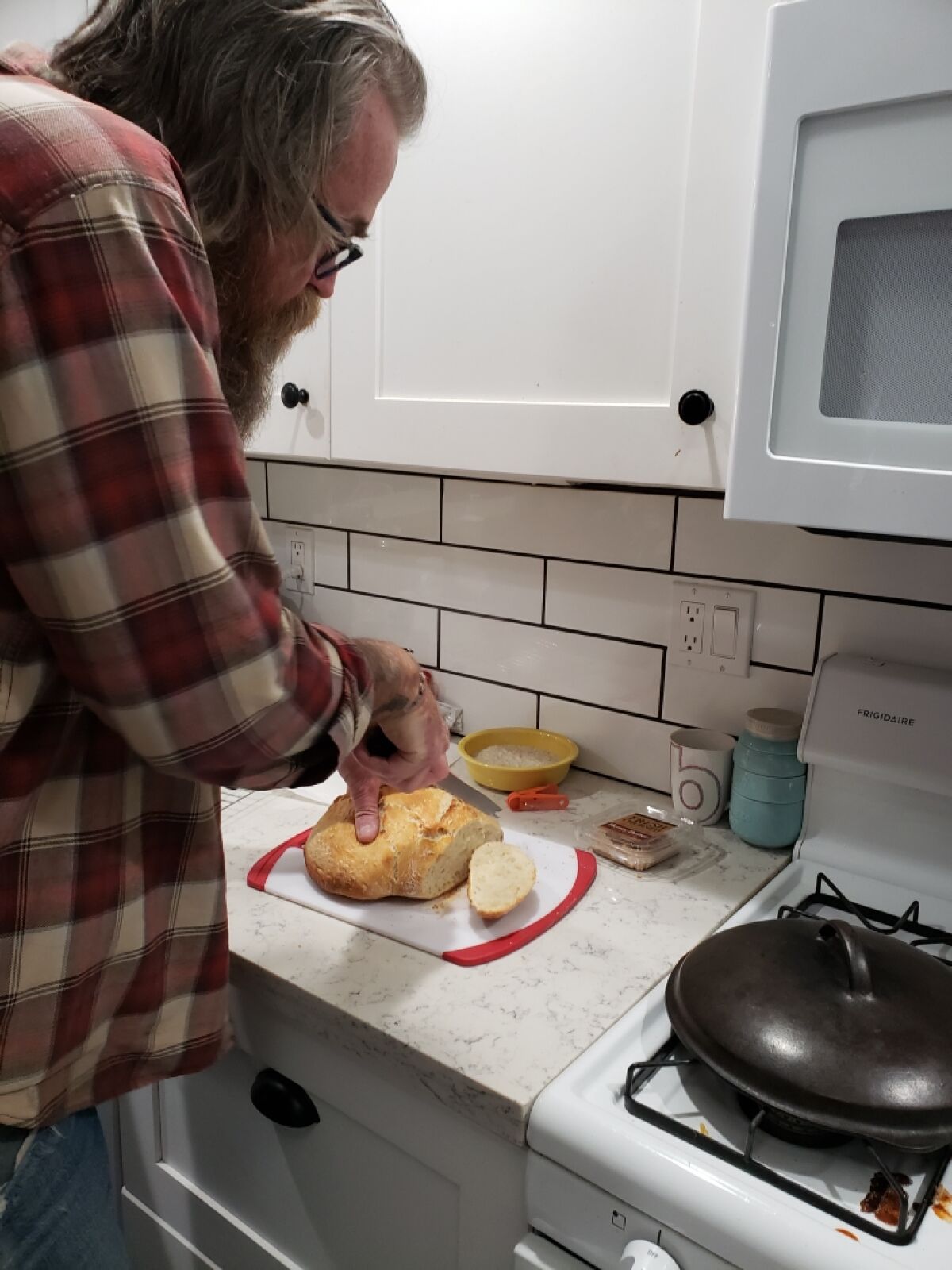 Brian Robbins of Escondido slices some bread he baked recently as part of his family's new homesteading hobby.