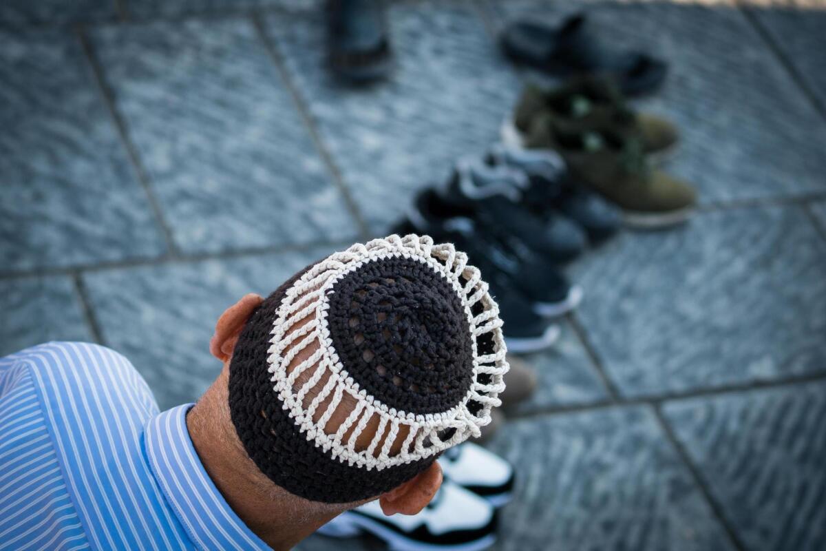 Italy: A man participates in a community prayer during Eid al-Adha celebrations at Garibaldi Square in Naples.