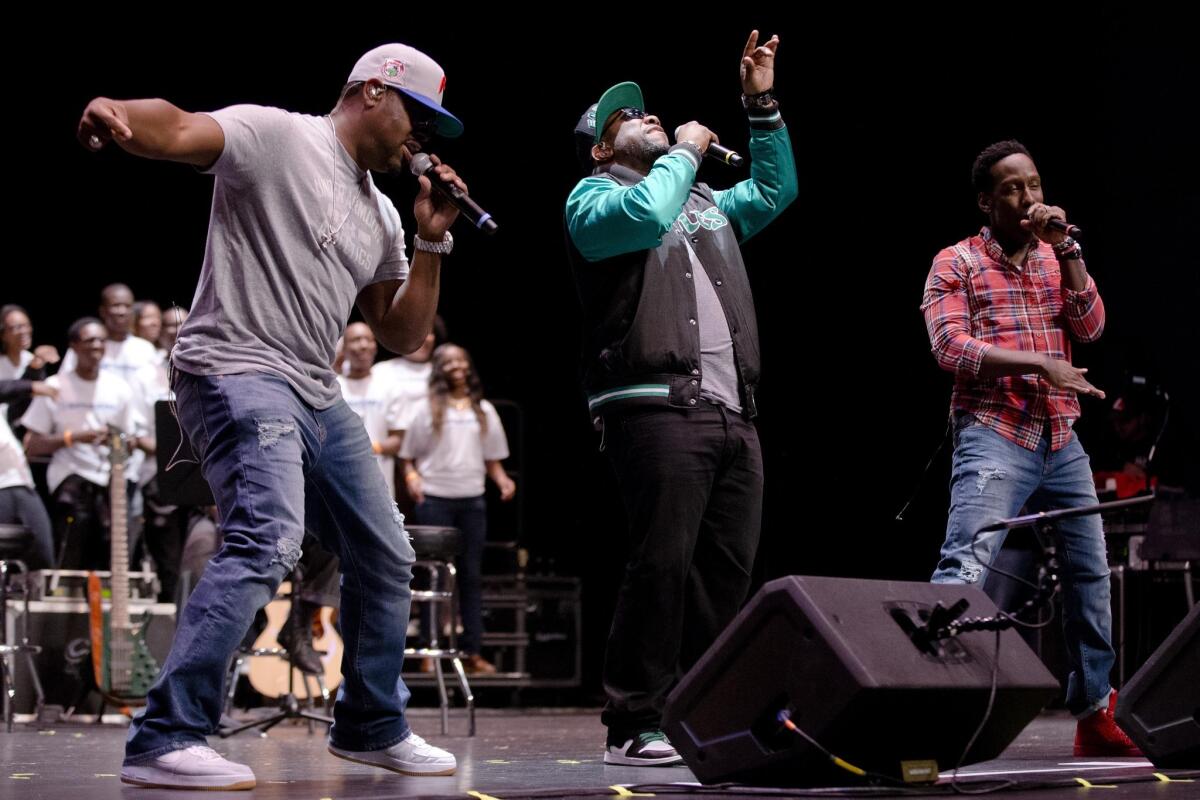Nathan Morris, left, Wanya Morris and Shawn Stockman of Boyz II Men, perform at their alma mater, Creative and Performing Arts High School, in Philadelphia on Oct. 14.