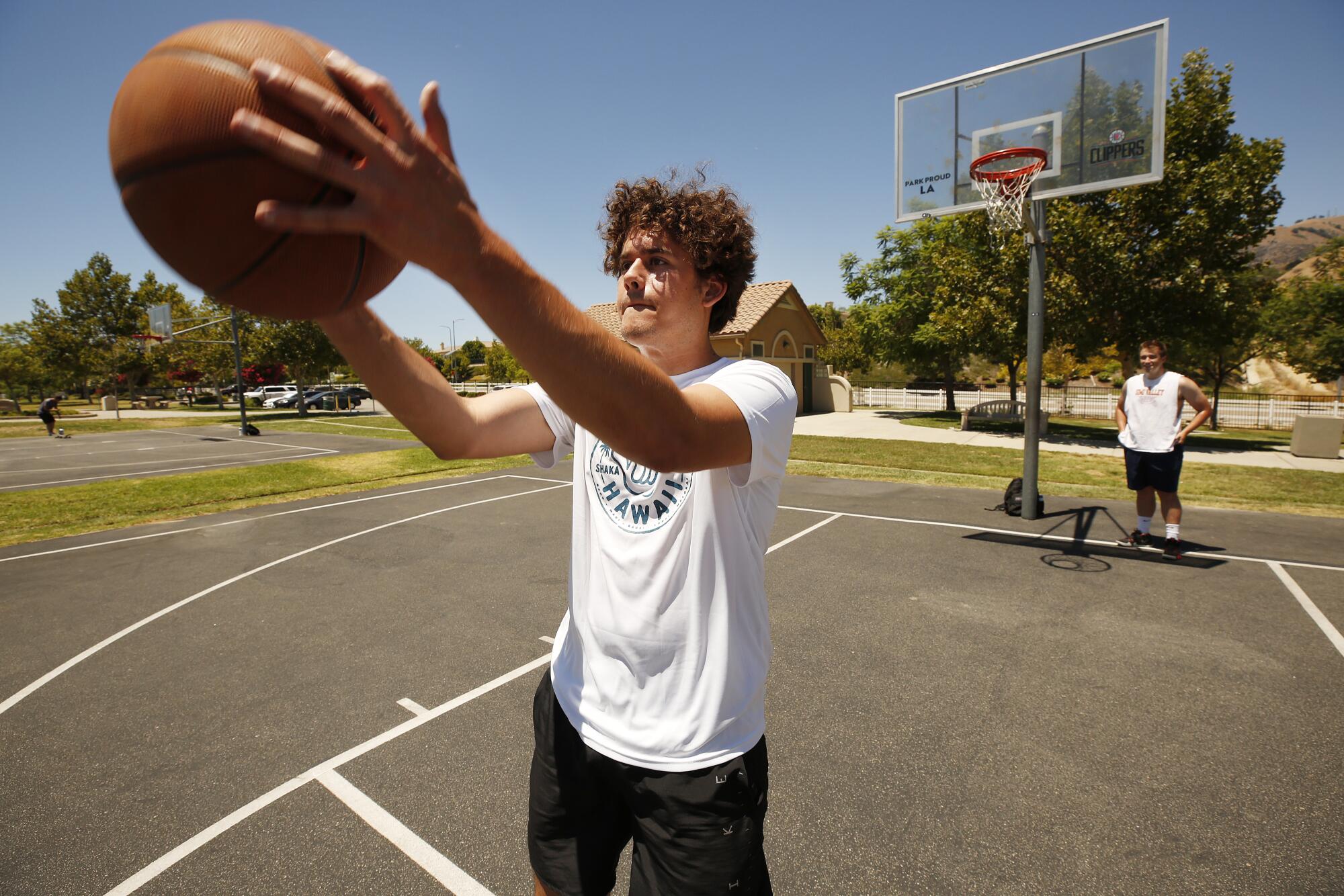 Gianmarco Bedon, 19, plays the basketball game of "HORSE" with his friend Joseph Blair on Aug. 2 at Porter Ranch Park.