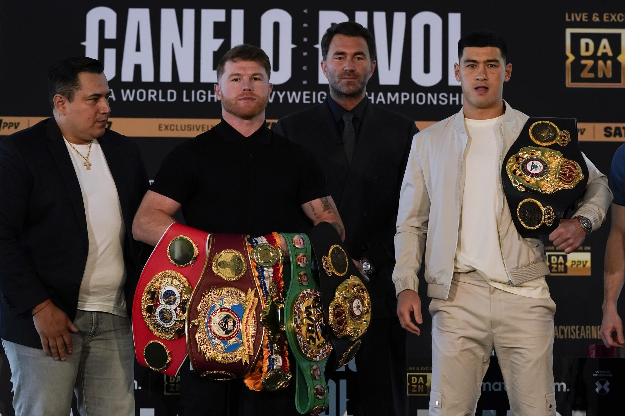 Canelo Alvarez, second from left, poses with Dmitry Bivol, right, during a news conference on March 2.