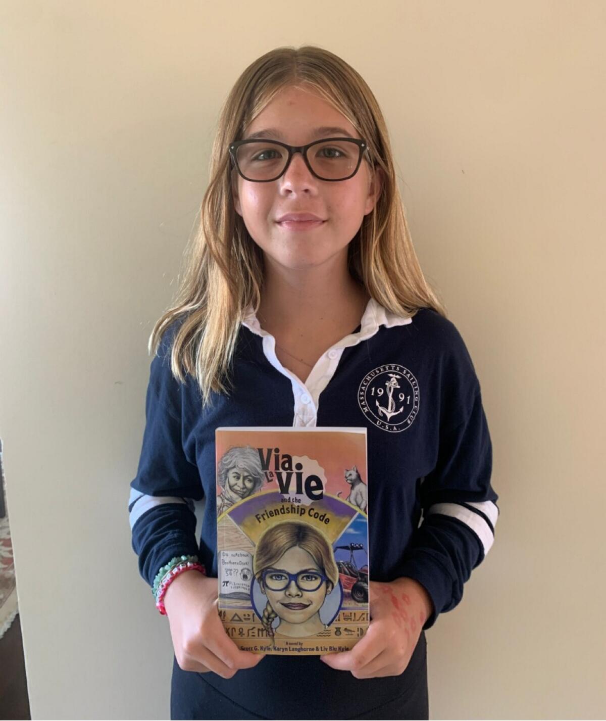 Muirlands Middle School student Liv Blu Kyle, 12, shows her book "Via LaVie and the Friendship Code."